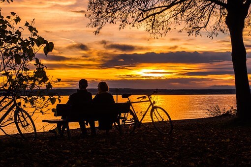 Imagem ilustrativa de um casal apreciando por do sol